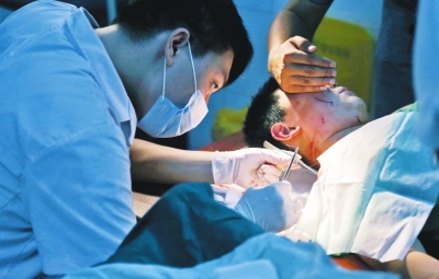 孩子身上有7道傷痕，其中兩道需要縫合，其他的均為擦傷，醫(yī)生正對他施治。