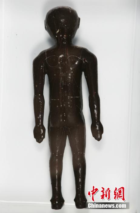 圖為出土的人體經(jīng)穴漆俑。