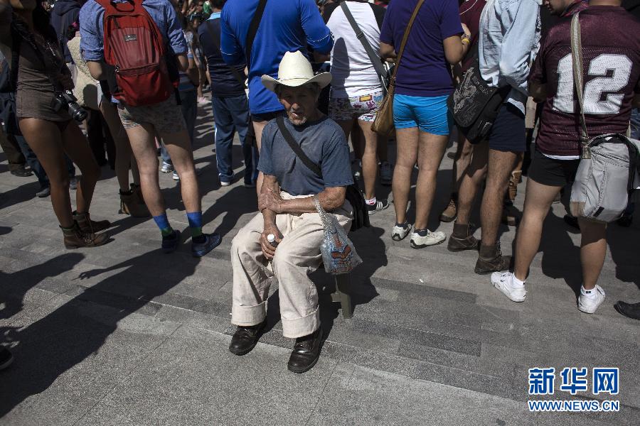 一名男子坐在參加不穿褲子搭地鐵的人群邊小憩。