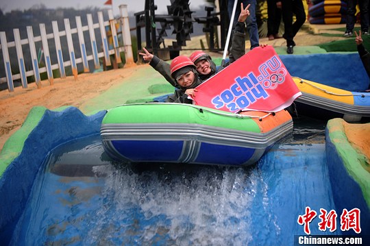 　圖為外國友人舉著標(biāo)語體驗(yàn)水上漂。陳超　攝