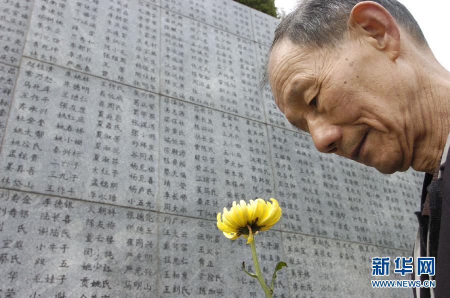 2006年4月5日，74歲的南京大屠殺幸存者佘子清手捧鮮花，祭奠被日軍殺害的母親。