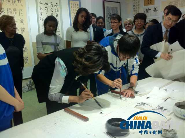　北京時(shí)間3月21日，美國第一夫人米歇爾參觀北師大二附中時(shí)，與學(xué)生一起練習(xí)書法。