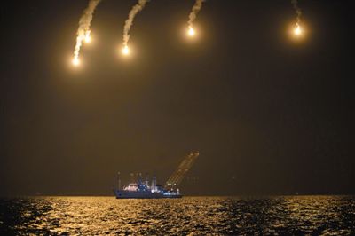 22日，搜救人員在照明彈的光亮下連夜搜救。