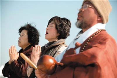 23日，一名僧侶引領(lǐng)人們?yōu)樗勒咂矶\。