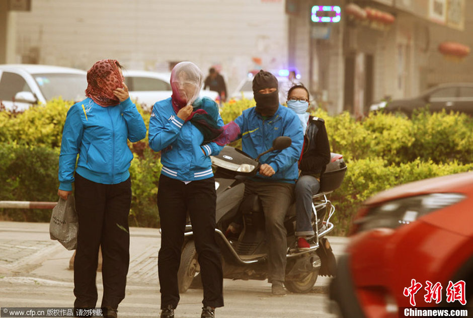 2014年04月23日，新疆維吾爾自治區(qū)吐魯番地區(qū)，市民戴著口罩行走在大風沙塵中的吐魯番市街頭。