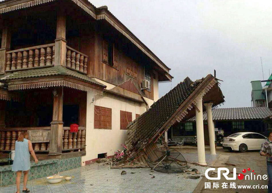 當(dāng)?shù)貢r間2014年5月5日，泰國清萊，一名婦女看著受損的房屋。 圖片來源：東方IC