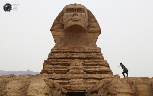 石家莊郊外，一名男子與山寨版獅身人面像合影留念。