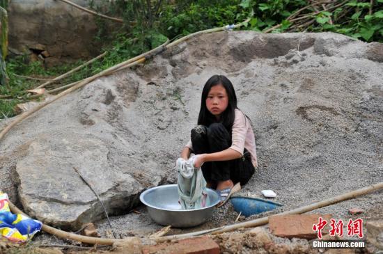 8月9日，云南巧家紅石巖村，10歲的劉鑫蕊在洗自己的衣服