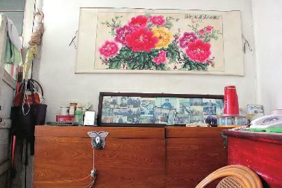 　陳會英將兒女的照片都裱起來，裝在一個大相框里，放在箱子上經(jīng)?？矗渲凶疃嗟木褪莿⒔饑恼掌?。