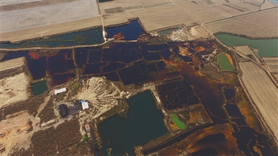 4月19日，廊坊市大城縣南趙扶鎮(zhèn)，津保路以北約八九百米處，一個巨大的污水坑中，水體呈現(xiàn)紅褐色。 新京報記者 尹亞飛 攝