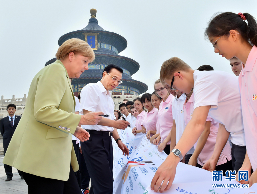 李克強同默克爾在紀念橫幅上簽名。