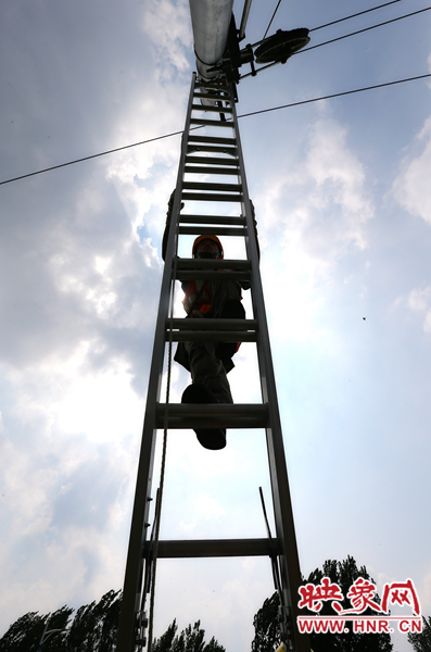 頂著太陽(yáng)的直射，檢修工不斷要爬上高處施工