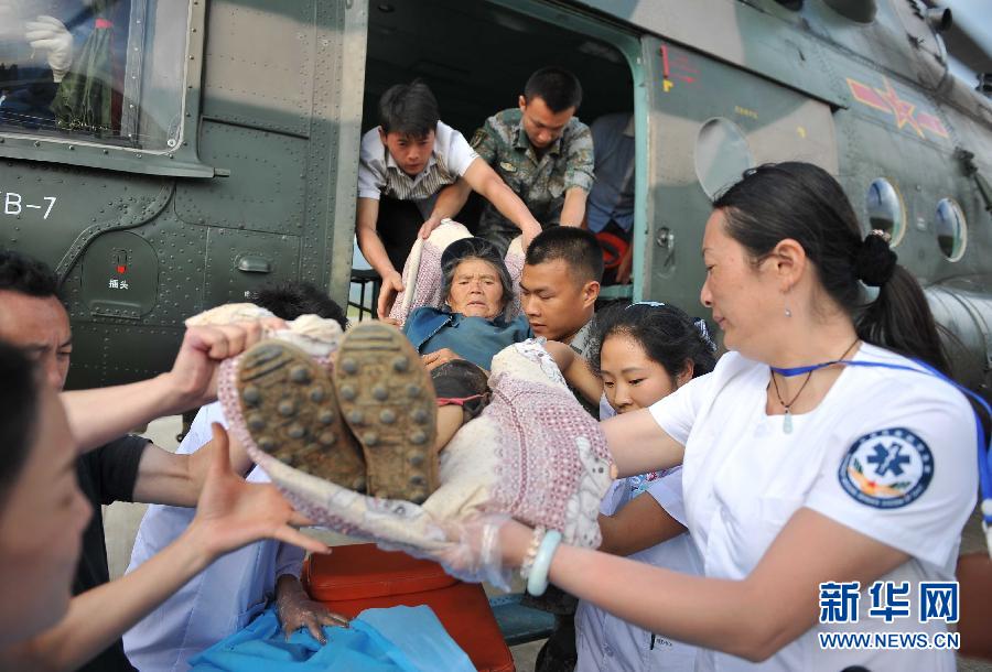 8月5日，醫(yī)護(hù)人員將一名通過直升機從震中轉(zhuǎn)運出來的傷員運下飛機。