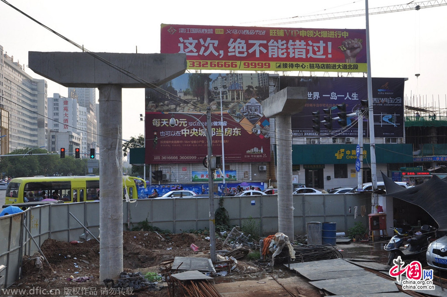 過街天橋一側(cè)的橋樁早已打好,可是對面的郵政銀行網(wǎng)點(diǎn)依舊在照常營業(yè)。