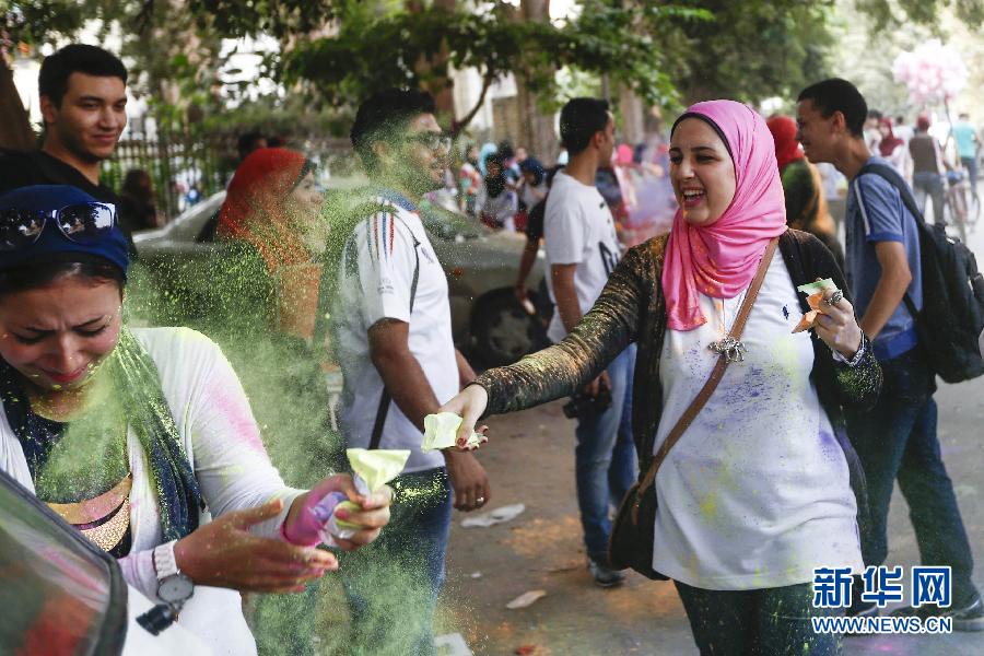 10月16日，在埃及首都開羅，一名女青年在“彩色跑”活動中拋撒彩色粉末。
