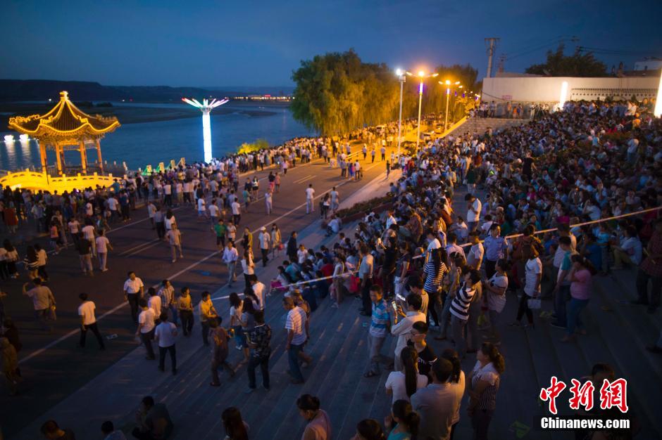 數(shù)萬民眾前來黃河邊觀看河燈。 張?jiān)?攝
