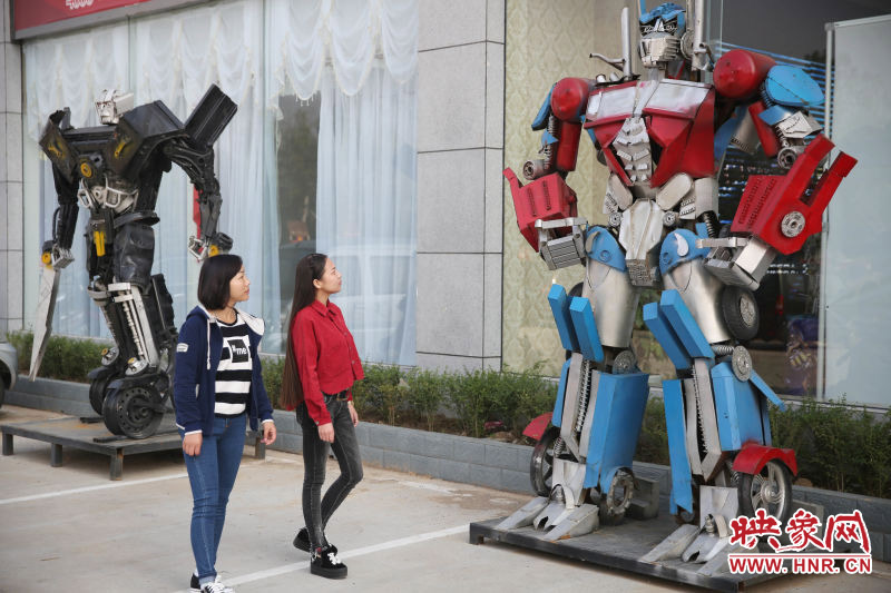 10月14日，市民在參觀河南省平頂山市寶豐縣一家企業(yè)門前的“變形金剛”。