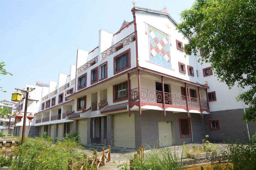 2016年7月26日，村民在廣西來賓市忻城縣隆達(dá)山水福城荒廢別墅間放牛。