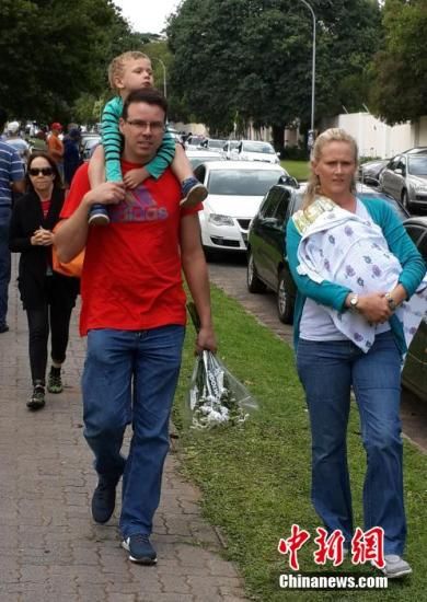 圖為一個白人家庭，由父母帶著孩子到曼德拉家門外悼念。中新社發(fā) 宋方燦 攝