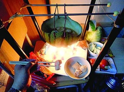 兩張椅子被面對(duì)面疊在一起，穿了兩根線的西瓜皮就懸空在椅腳中間，下面有蠟燭加熱，這就是西瓜火鍋。