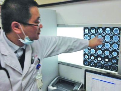 醫(yī)生在查看男孩的腦部CT片。薛馬義 攝