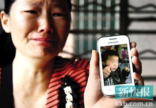男童的舅媽拿著小益的照片,悲痛欲絕。 新快報(bào)記者 畢志毅 攝