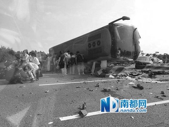 現(xiàn)場大客車側(cè)翻，玻璃碎落一地，車身卡在路邊水泥護欄上。 目擊者供圖