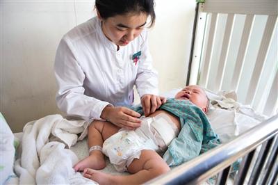 昨日，北京兒童醫(yī)院，護(hù)士為即將出院的被扎鋼針女嬰檢查傷口恢復(fù)情況。記者 高瑋 攝