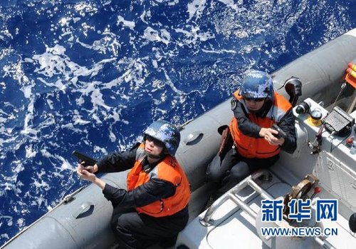 　3月28日，十余名臨檢拿捕隊員乘小艇駛至模擬可疑商船下方水面。