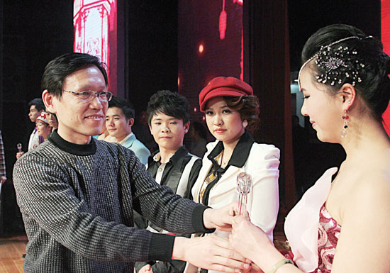 2013年2月1日，《對9當(dāng)歌》總決賽在鄭州開唱。圖為東方今報(bào)副社長胡楊為選手頒獎(jiǎng)