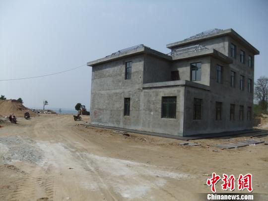 鴨河水庫庫區(qū)邊的新建別墅，一面墻上寫著“拆”，另一邊在加緊施工。吳揚　攝